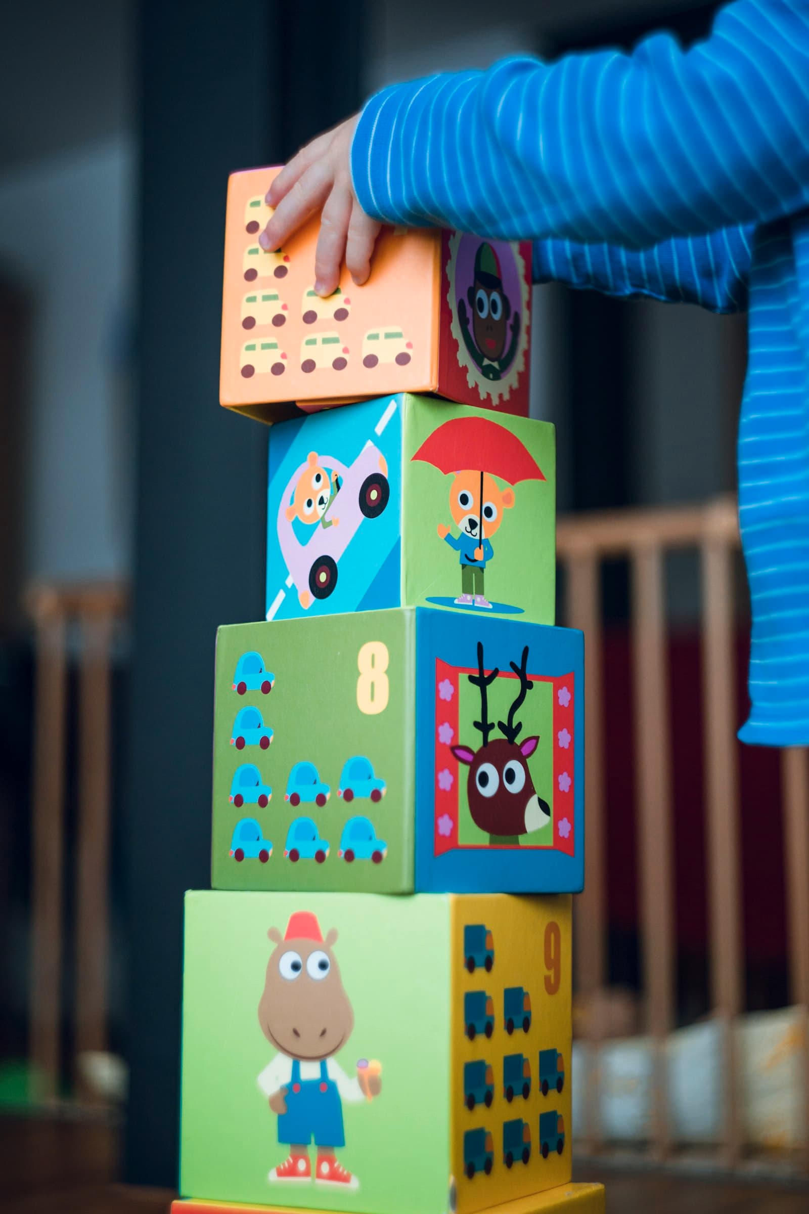 A toddler stacking colorful cardboard blocks